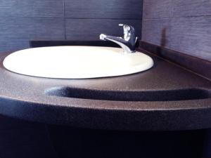 a white sink in a bathroom with a black wall at La Vallata B&B in Sardegna in Ghilarza