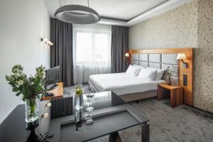 une chambre d'hôtel avec un lit et une table dans l'établissement Sea Premium Apartments - Destigo Hotels, à Gdynia