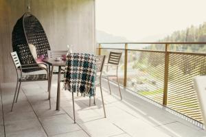 un tavolo e sedie su un balcone con vista di Peaks Place Apartments & SPA a Laax