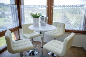 - une table et des chaises dans une chambre avec fenêtre dans l'établissement Hotel Villa Golf Cihelny, à Karlovy Vary