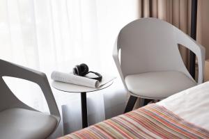 - une chambre avec deux chaises, une table et un lit dans l'établissement Hotel Arkon Park Gdańsk- Destigo Hotels, à Gdańsk