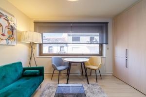 ein Wohnzimmer mit einem Sofa, einem Tisch und Stühlen in der Unterkunft SUITE DE LUJO PUERTA DEL SOL+Parking in Vigo