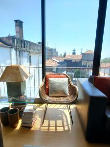 a rattan chair in a room with a large window at Between River and Sea Porto Apartment in Porto