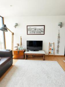 a living room with a couch and a flat screen tv at Between River and Sea Porto Apartment in Porto