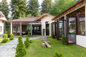 a house with glass doors and a garden at No 107 Predeal in Predeal