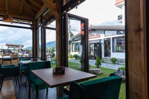 a restaurant with green chairs and a table and windows at No 107 Predeal in Predeal