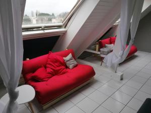 ナントにあるSuperbe loft 90m² proche parc expo Nantes (6p)の窓付きの客室で、赤いソファが備わります。