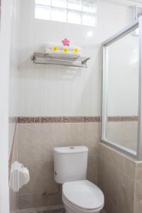 baño con aseo blanco y ventana en Bali Seascape Beach Club, en Candidasa