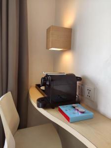 einen Toaster auf einer Theke mit einem Buch darauf in der Unterkunft Liberta Hotel Kemang in Jakarta