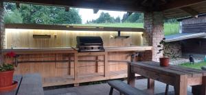 a outdoor kitchen with a grill and a table at Apartments Cederika in Věžovatá Pláně