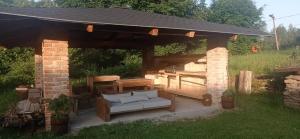 a pavilion with a couch in a yard at Apartments Cederika in Věžovatá Pláně