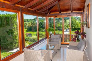 a screened in porch with chairs and windows at Holiday Home Mare near River in Karlovac