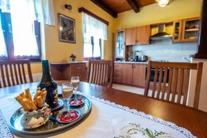 a table with a bottle of wine and a plate of food at Holiday Home Mare near River in Karlovac