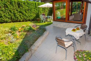 a patio with a table and chairs in a yard at Holiday Home Mare near River in Karlovac