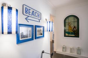 a hallway with three pictures and a sign on the wall at Casa "Vó Minda" - Nazaré - Alojamento Local in Nazaré