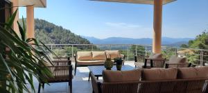 d'un balcon avec des chaises et des tables offrant une vue sur les montagnes. dans l'établissement Les Hauts du Peireguier, à La Motte