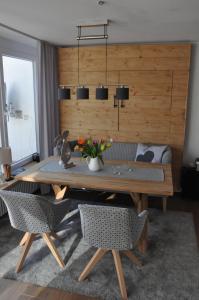 een eetkamer met een houten tafel en stoelen bij ALMI - Alpenglück Traumhafte Whg.m.20qm Dachterr. in Oberstaufen