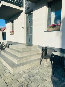 une terrasse avec des escaliers, une table et des chaises dans l'établissement Apartmány TAMKA, à Vrbov