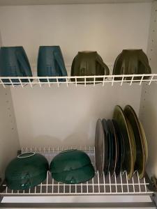 four green bags on a shelf in a closet at ADI Apartamentai in Panevėžys