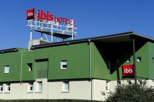 un edificio verde con un cartel encima en ibis Lyon Est Beynost, en Beynost