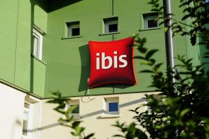 una señal roja en un lado de un edificio verde en ibis Lyon Est Beynost, en Beynost