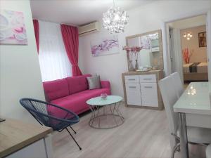 sala de estar con sofá rosa y mesa en City Lux Apartments, en Skopje