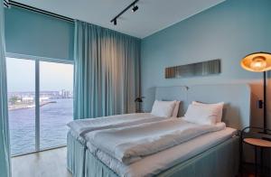 um quarto com uma cama grande e uma janela grande em Scandic Oceanhamnen em Helsingborg