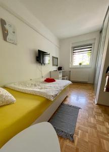 Un dormitorio con una gran cama amarilla y una ventana en DIS apartment Varaždin, en Varaždin