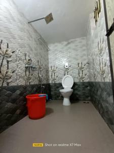 - une salle de bains pourvue de toilettes et d'une poubelle rouge dans l'établissement Palolem Sunrise Apartment, à Palolem