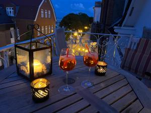 - deux verres de vin sur un balcon la nuit dans l'établissement Sandwallkoje, à Wyk auf Föhr