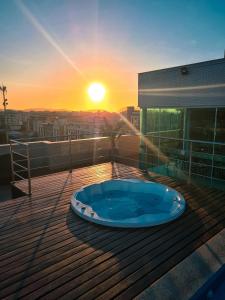 un bain à remous sur une terrasse avec le coucher du soleil en arrière-plan dans l'établissement Paradiso Corporate, à Cabo Frio