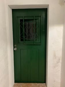 une porte verte avec une fenêtre sur un mur dans l'établissement Casa dos Tios, à Veiros