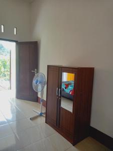 a room with a fan and a wooden cabinet at Tiu Kelep Homestay in Senaru