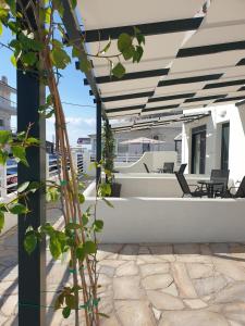 an outdoor patio with a white and black pergola at Eantos Studios and Suites in Perea