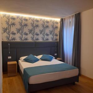 A bed or beds in a room at Bike Hotel Touring Gardone Riviera & Wellness