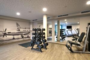 a fitness room with a helicopter and tread machines at ATLANTIC Hotel Airport in Bremen