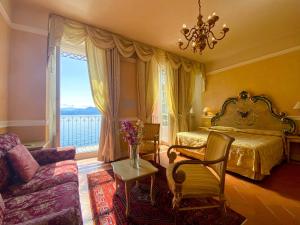 a bedroom with a bed and a couch and a window at Hotel Cannero in Cannero Riviera