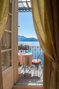 a balcony with a table and a view of the water at Hotel Cannero in Cannero Riviera