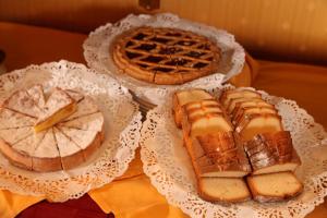 drei verschiedene Brotsorten und Pasteten auf weißen Platten in der Unterkunft Hotel Serena srl in Rom