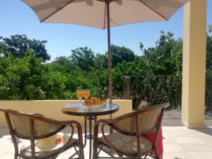 - une table et des chaises avec un parasol sur la terrasse dans l'établissement BELLA CISTERNA, à Kambos