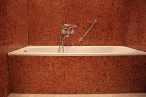 a bath tub in a red tiled bathroom at Hotel Deutscher Kaiser in Nürnberg