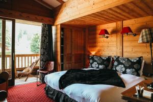 um quarto com uma cama num quarto com uma varanda em Les Grands Montets Hotel & Spa em Chamonix-Mont-Blanc