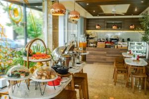 a restaurant with many plates of food on tables at Amber Beach Hotel in Hulhumale