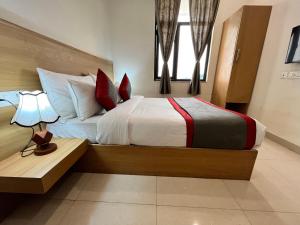 a bedroom with a large bed with a lamp on a table at HOTEL TNCS - Couple Friendly Local IDs Accepted in Noida