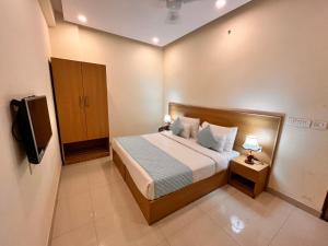 a hotel room with a bed and a television at HOTEL TNCS - Couple Friendly Local IDs Accepted in Noida