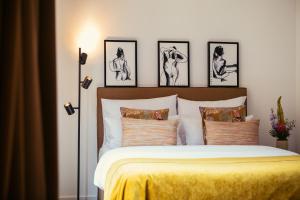 een slaapkamer met een bed met vier foto's aan de muur bij The Weinmeister Berlin-Mitte - Adults Only in Berlijn