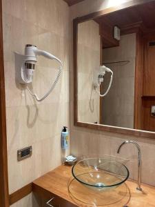 a bathroom with a glass sink and a mirror at Les Neiges D'Antan in Breuil-Cervinia