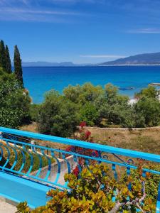 un banc bleu avec l'océan en arrière-plan dans l'établissement Julia's Apartment, à Kalamata