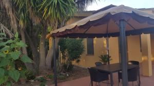 a table and chairs under an umbrella on a patio at Casa Margherita in Càbras