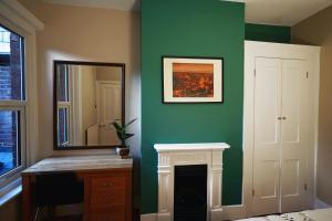 a green room with a mirror and a fireplace at Tastefully Decorated 1-Bed with Free Parking - At Hem in Winchester